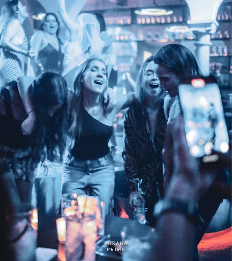 Chica celebrando con botella de vodka premium en República Cozana